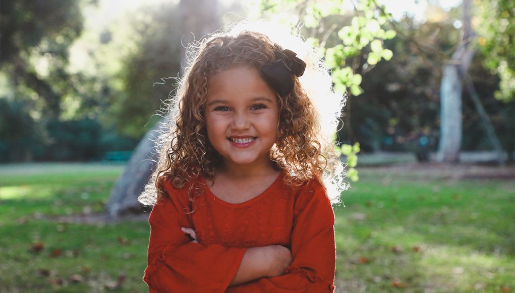 young girl smiling with arms folded