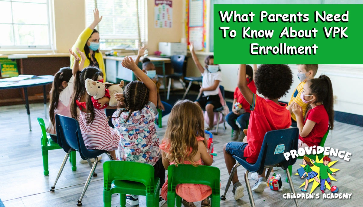 children in class sitting in a circle with hands raised
