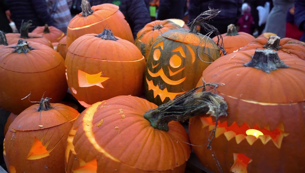 a pile of decorated pumpkin lamps