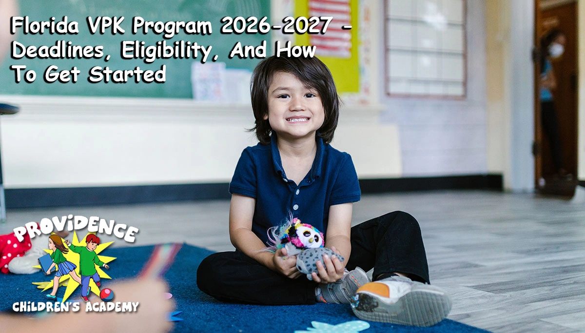 Young boy sitting on the floor in a classroom smiling