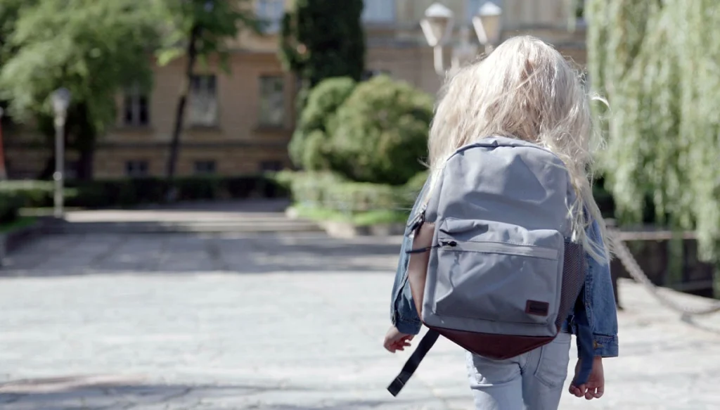 little girl walking towards a school.